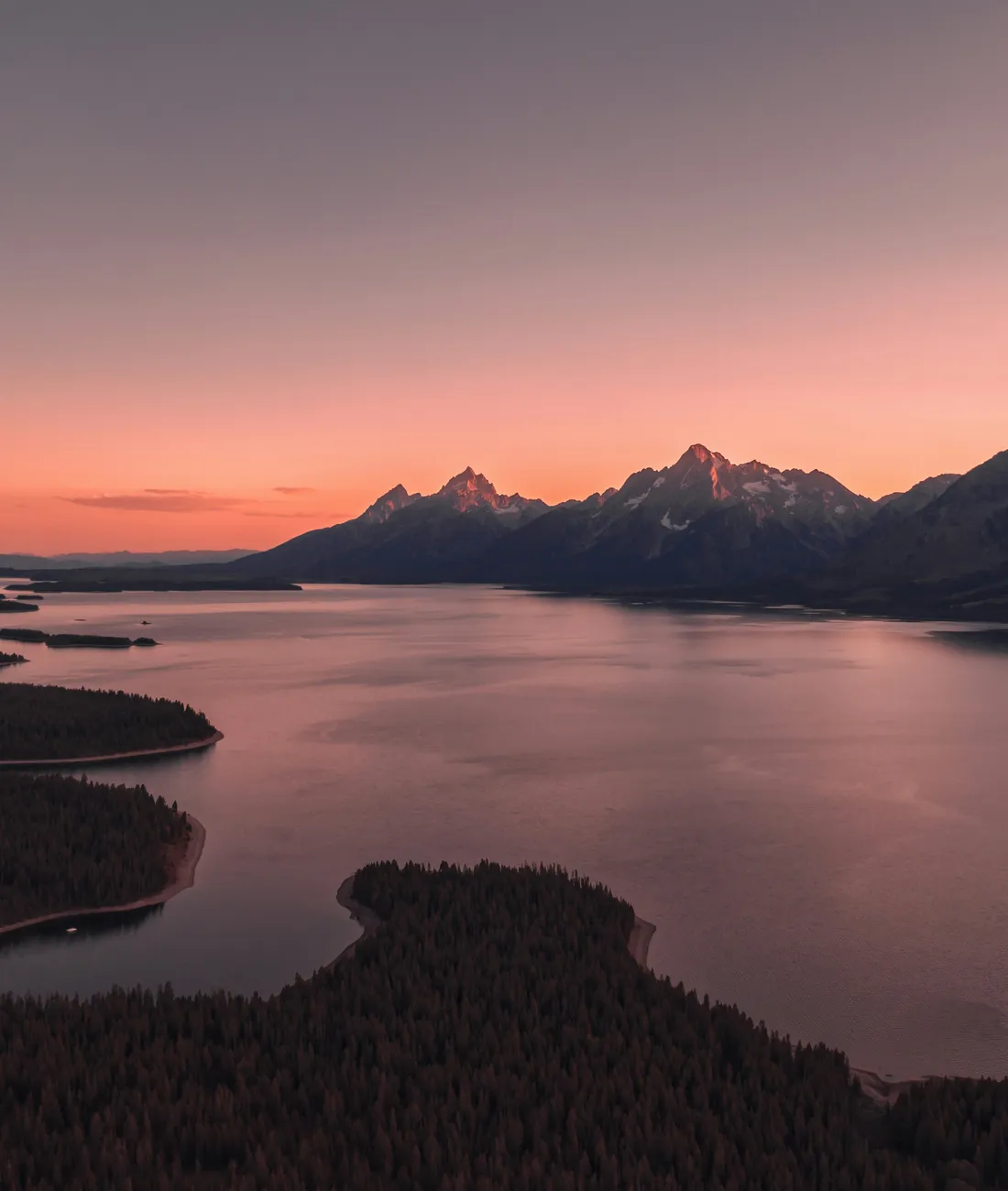 Mountain lake and rugged peaks at sunset in Wyoming