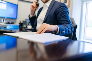 Trustee reviewing records while speaking by telephone