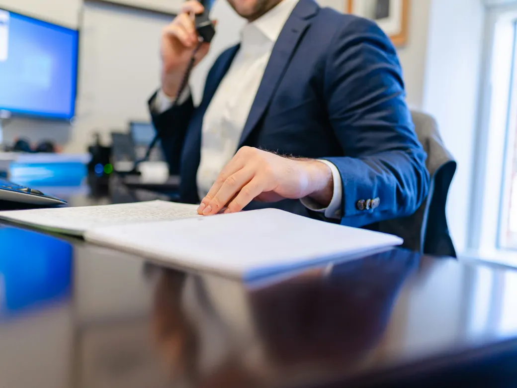 Trustee reviewing records while speaking by telephone
