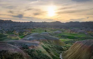 Sunrise over layered badlands terrain in South Dakota